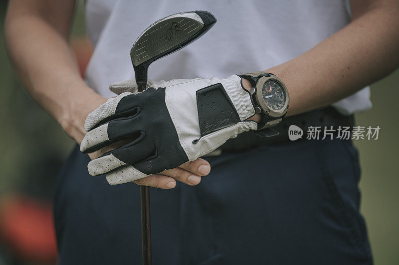 Crop shot of asian young man golfer hand holding golf club on the golf course